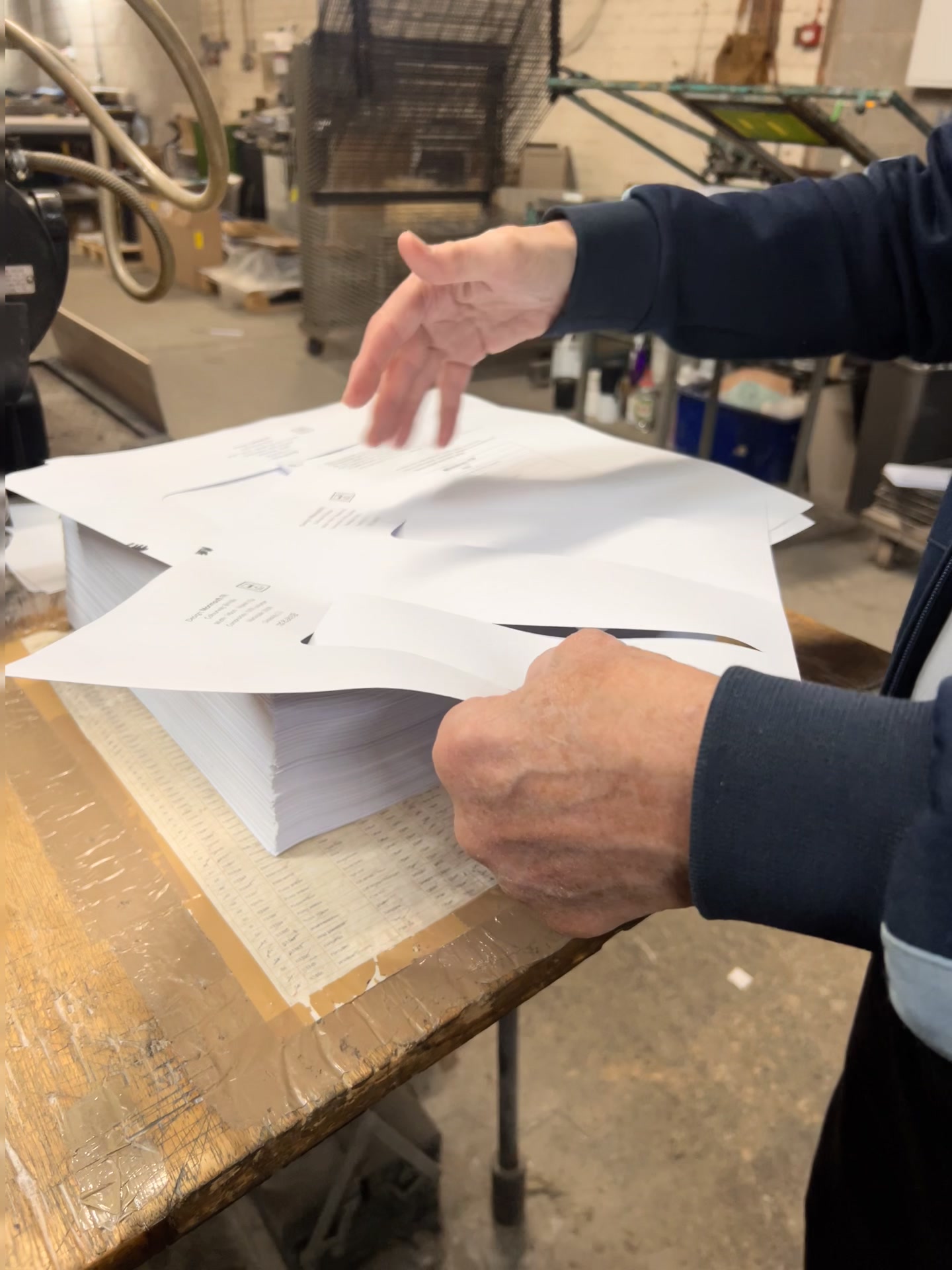 Printed sheets for the sample book being checked and separated by hand